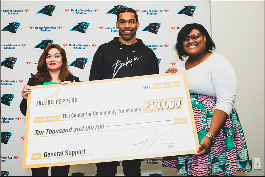 Julius Peppers presents Center for Community Transitions with a $10,000 check.